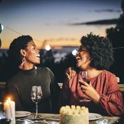 cheerful female friends enjoying wine at birthday