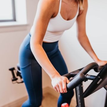 Close up of woman riding exercise bike in home gym close up of woman riding exercise bike in home gym