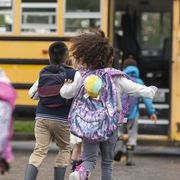 diverse group of happy children getting on school bus