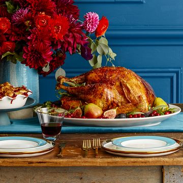 thanksgiving turkey and pie on the dinner table with a bouquet of flowers