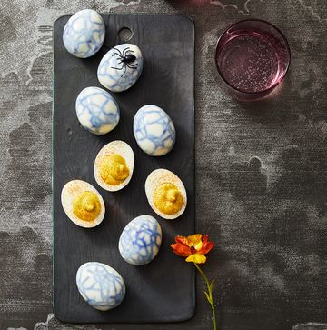 blue spider webbed deviled eggs on a black board blue spider webbed deviled eggs on a black board