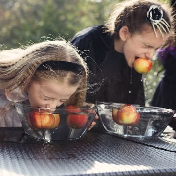 halloween games two older children playing halloween bobbing for apples game