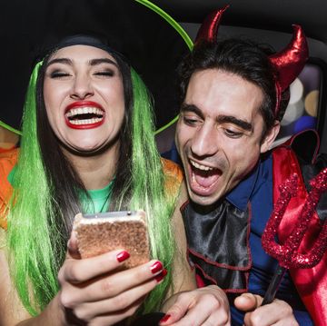 halloween witch and devil laughing in back of car