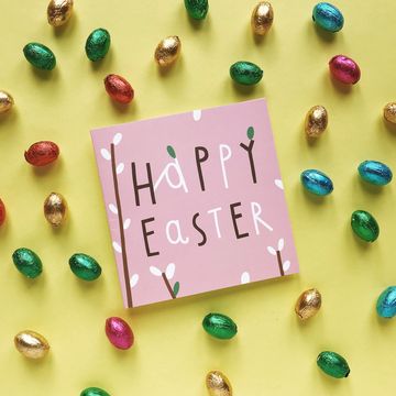 High Angle View Of Greeting Card With Easter Eggs On Yellow Background high angle view of greeting card with easter eggs on yellow background