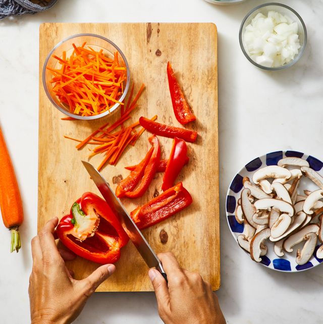 red bell pepper being cut up on a wooden board