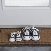 two pairs of sneakers on a doormat