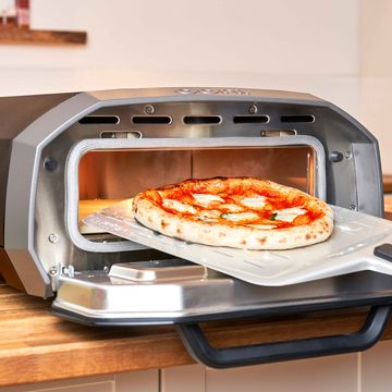 ooni volt 12 with pizza on a peel