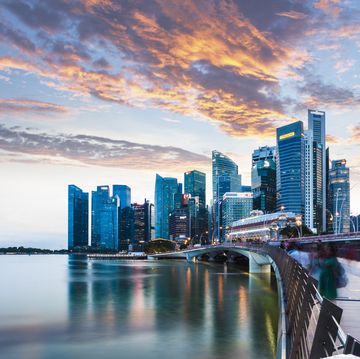 singapore skyline at marina bay at twilight with glowing sunset illuminating the clouds