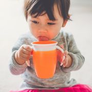 a toddler girl drinks from her sippy cup