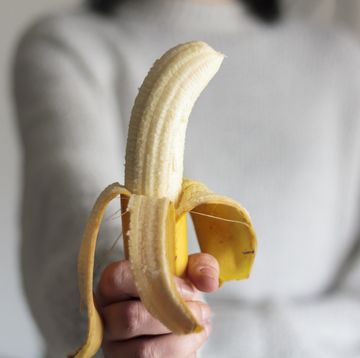 woman holding a peeled banana