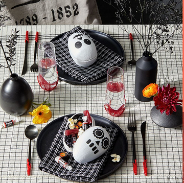 halloween party ideas, skeleton candy holder on black plates, open bottles with halloween labels