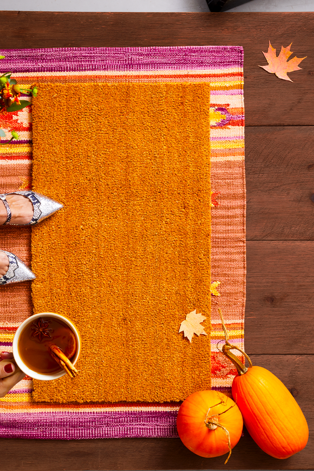hand holding a beverage over thanksgiving decor